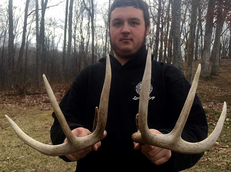 Man holding shed deer antlers